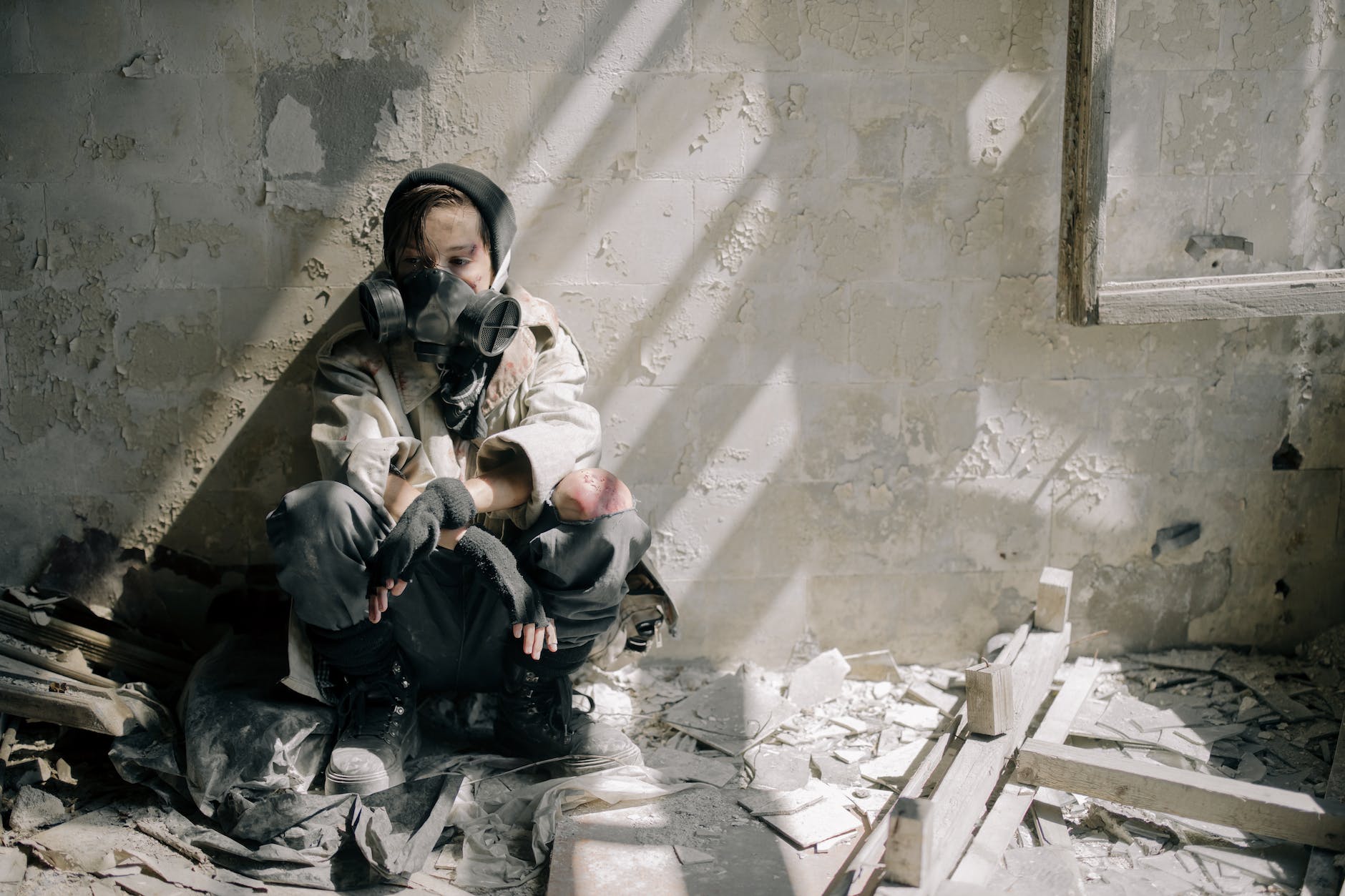 woman in white jacket sitting on concrete stairs | Causes of air pollution | A women wearing mask at home.