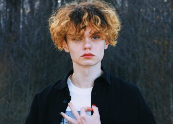 portrait of a boy with curly hair wearing a black shirt