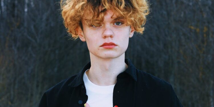 portrait of a boy with curly hair wearing a black shirt