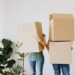 Bridge Mortgage: Change Your House Before Selling Yours | couple carrying cardboard boxes in living room