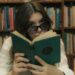 woman with sunglasses reading book in library