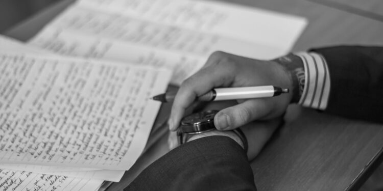grayscale photography of person holding pen | i'mBiking magazine allows writers to submit their creative writing prompts and advertise their blog links for free.