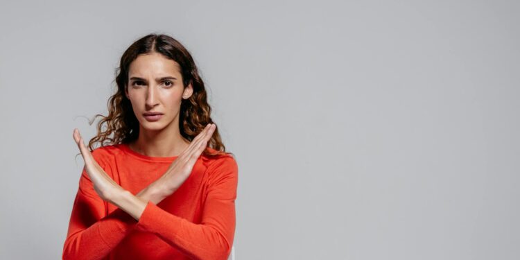 woman in red long sleeve shirt: Feeling the sting of rejection? This candid article explores why "no" isn't final, how to process the pain, and how rejection can actually reshape you into a stronger, truer version of yourself.