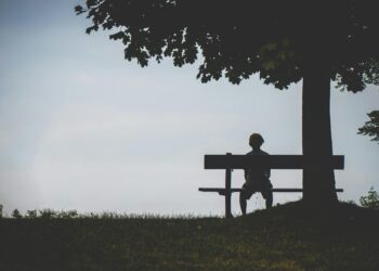 person sitting on bench under tree: Feeling like you're "too much"? You're not alone — you're exactly what this world needs. A love letter to deep feelers, dreamers, and those who care big.