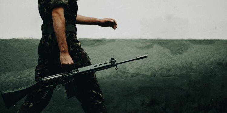 soldier holding gun: A stirring poetic reflection on the horrors of war, nuclear threat, pandemics, and modern militarization—World War Web Discourse – Never Again urges humanity to choose peace, unity, and welfare over destruction.