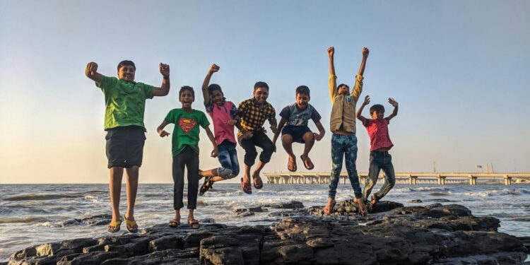 Ignite young minds, inspire innovation, and lead with higher thinking—discover how visionary habits and disruptive ideas shape tomorrow’s industrial and scientific future : boy wearing green crew neck shirt jumping from black stone on seashore